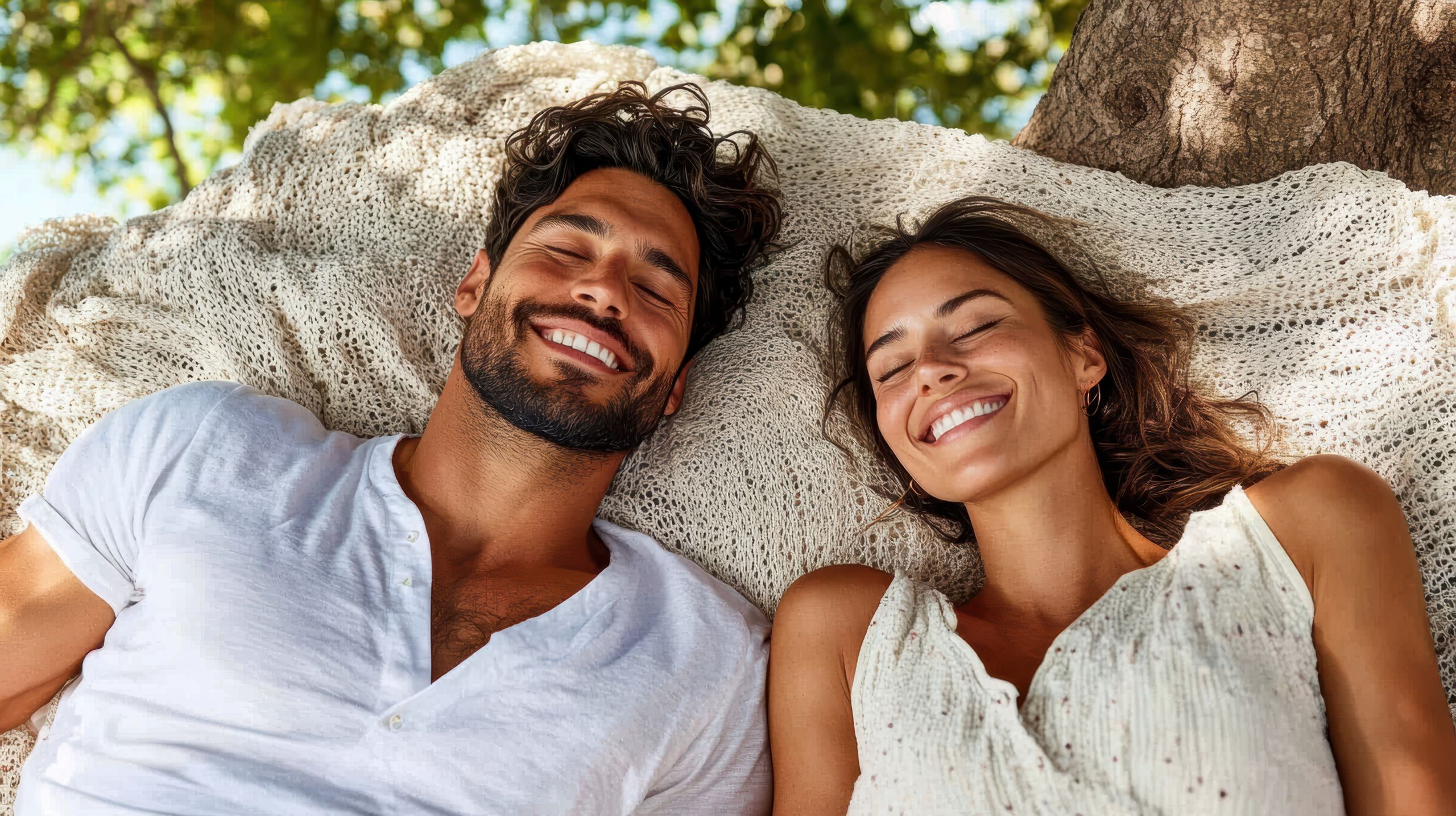 Couple lying on blanket under tree shade, enjoying tranquil moment together